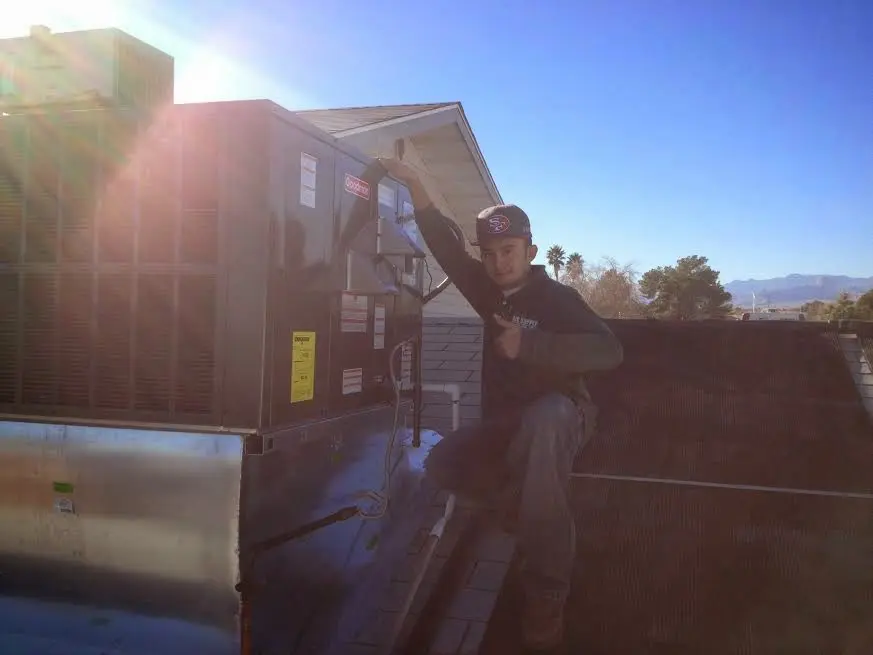 HVAC technician performing Heat Pump Repair on a rooftop unit in Irondale